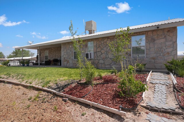 185 La Entrada Rd, Los Lunas, NM 87031 - rear view of property featuring stone siding, a metal roof, and a lawn