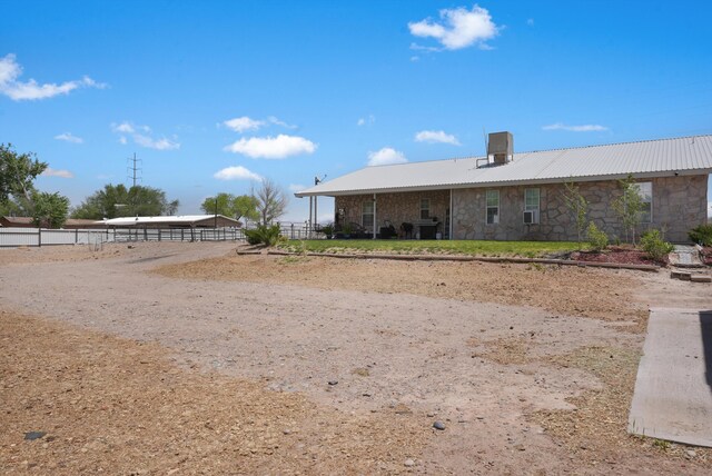 185 La Entrada Rd, Los Lunas, NM 87031 - back of house featuring stone siding and a metal roof