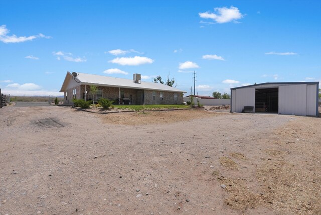 185 La Entrada Rd, Los Lunas, NM 87031 - rear view of house featuring an outbuilding, an outdoor structure, and driveway