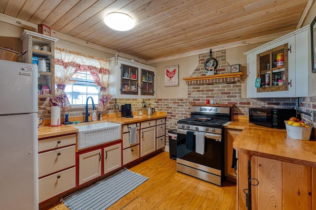 10 Berkshire Rd, Estancia, NM 87016 - kitchen with butcher block counters, gas stove, freestanding refrigerator, black microwave, and wood ceiling