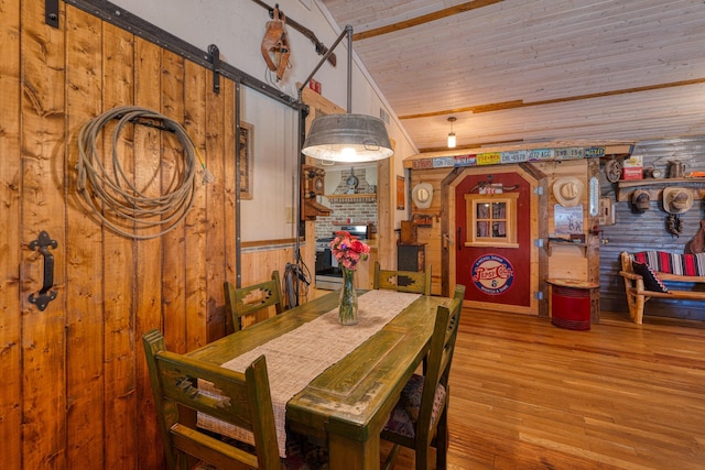 10 Berkshire Rd, Estancia, NM 87016 - dining room with wood ceiling, wood finished floors, vaulted ceiling, wooden walls, and a barn door