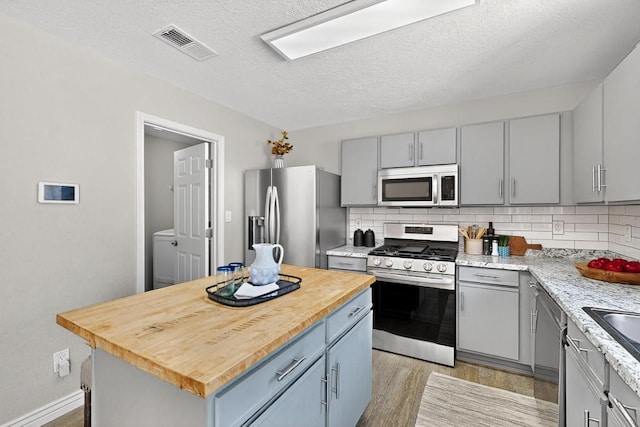 4001 Cresta Park Ave NW, Albuquerque, NM 87114 - kitchen featuring stainless steel appliances, gray cabinets, tasteful backsplash, and a textured ceiling