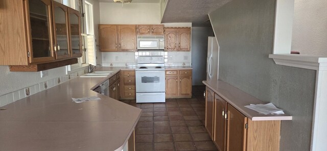 606 Eastlake Ct SE, Rio Rancho, NM 87124 - kitchen with white appliances, a sink, light countertops, a textured wall, and glass insert cabinets