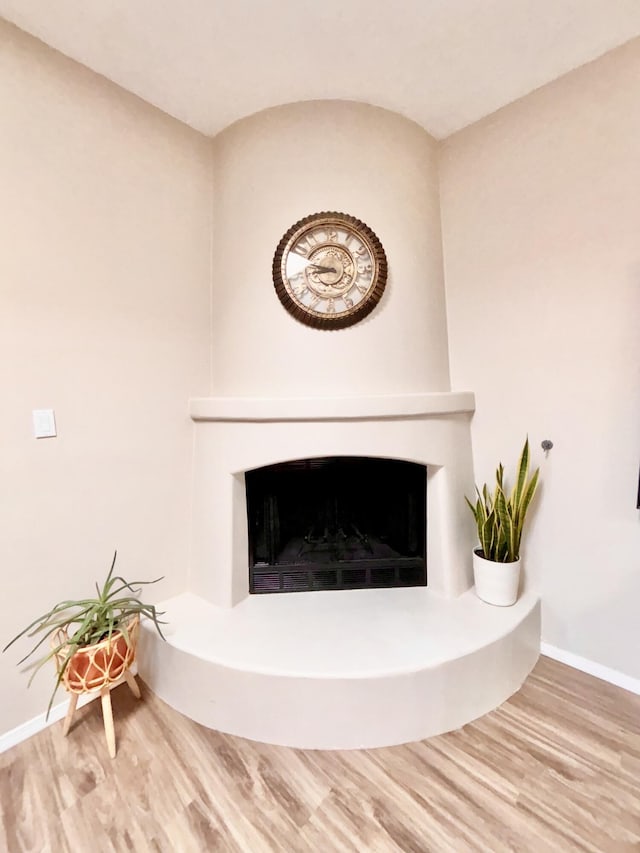 1704 Jack Nicklaus Dr, Rio Communities, NM 87002 - detailed view of a fireplace with raised hearth, wood finished floors, and baseboards