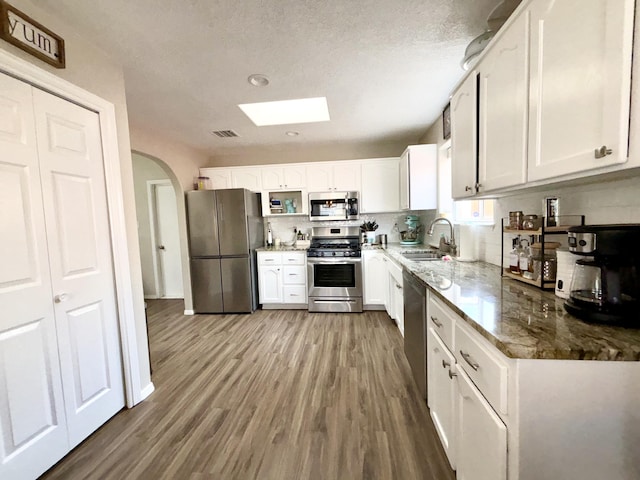 1704 Jack Nicklaus Dr, Rio Communities, NM 87002 - kitchen with appliances with stainless steel finishes, a sink, white cabinetry, light stone counters, and recessed lighting