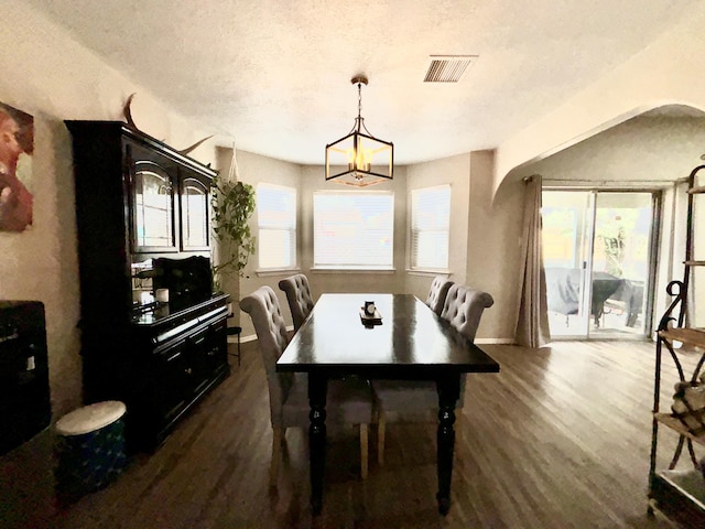 1704 Jack Nicklaus Dr, Rio Communities, NM 87002 - dining area featuring dark wood-style floors, arched walkways, a textured ceiling, and a chandelier