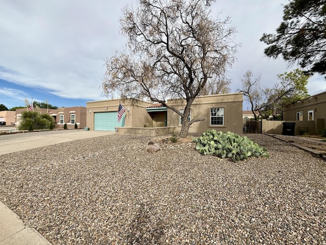 1704 Jack Nicklaus Dr, Rio Communities, NM 87002 - pueblo revival-style home with stucco siding, driveway, and an attached garage