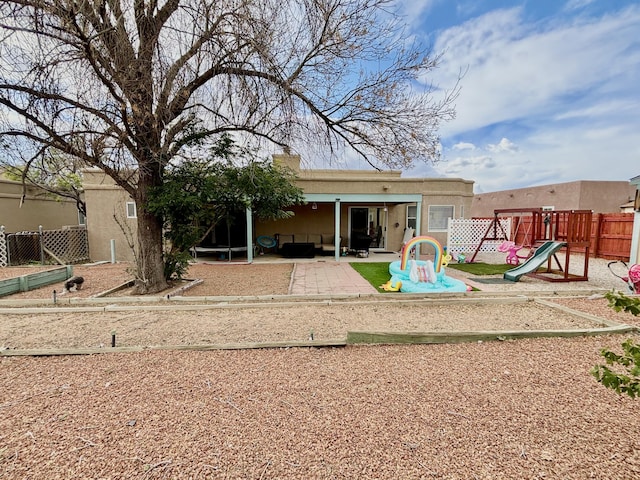 1704 Jack Nicklaus Dr, Rio Communities, NM 87002 - back of house with a playground and a patio