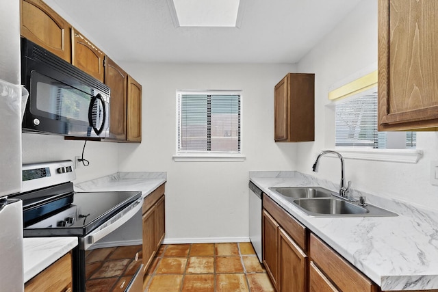 7939 Independence Dr NW, Albuquerque, NM 87120 - kitchen with appliances with stainless steel finishes, healthy amount of natural light, light countertops, and brown cabinetry