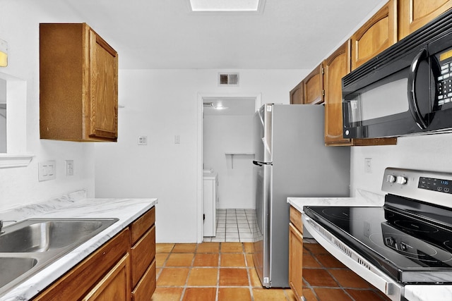 7939 Independence Dr NW, Albuquerque, NM 87120 - kitchen with electric range, black microwave, brown cabinets, and light countertops