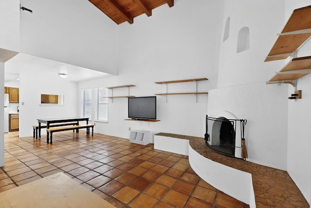 7939 Independence Dr NW, Albuquerque, NM 87120 - tiled living area with high vaulted ceiling, a wood ceiling with exposed beams, and a fireplace with raised hearth