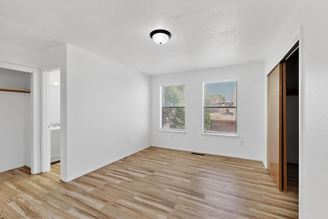 7939 Independence Dr NW, Albuquerque, NM 87120 - unfurnished bedroom with light wood-style flooring, a closet, and a textured ceiling