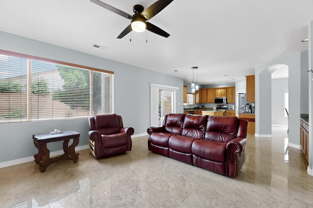 1468 Montiano Loop SE, Rio Rancho, NM 87124 - living area featuring ceiling fan, arched walkways, and light marble finish flooring