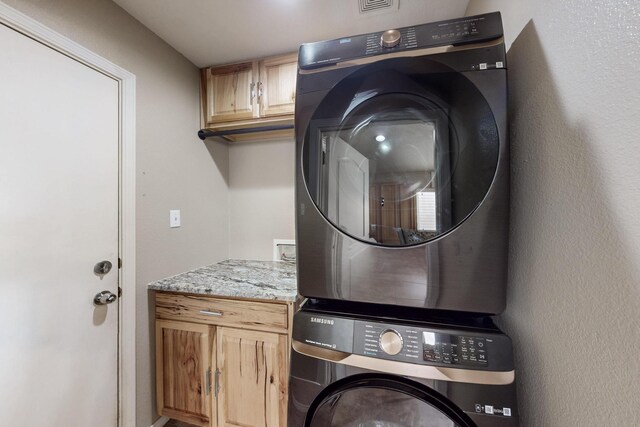2704 Ghost Ranch St SW, Albuquerque, NM 87121 - laundry room with stacked washer / drying machine and cabinet space