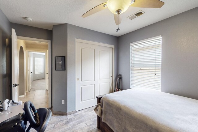 2704 Ghost Ranch St SW, Albuquerque, NM 87121 - bedroom with a closet, multiple windows, light wood-type flooring, and a ceiling fan