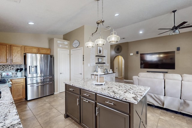 2704 Ghost Ranch St SW, Albuquerque, NM 87121 - kitchen featuring stainless steel fridge with ice dispenser, arched walkways, a ceiling fan, open floor plan, and light stone counters
