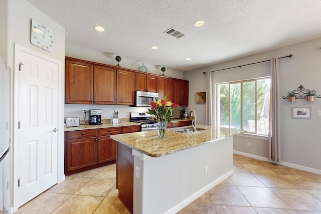 613 Loma Linda Loop NE, Rio Rancho, NM 87124 - kitchen featuring stainless steel appliances, light stone counters, recessed lighting, light tile patterned floors, and a center island with sink