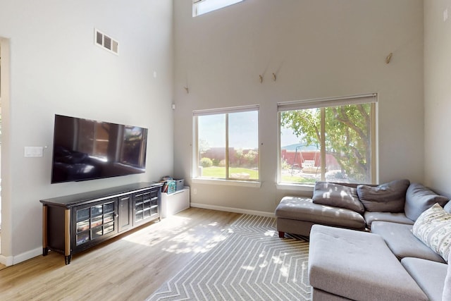 613 Loma Linda Loop NE, Rio Rancho, NM 87124 - living room featuring a towering ceiling, plenty of natural light, and wood finished floors