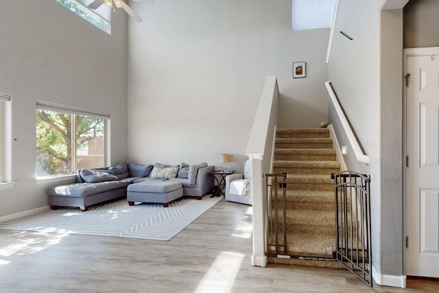 613 Loma Linda Loop NE, Rio Rancho, NM 87124 - living room with a towering ceiling, wood finished floors, a ceiling fan, and stairway