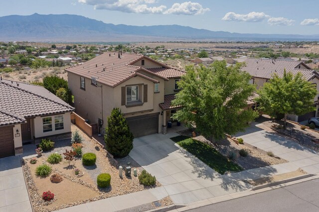 613 Loma Linda Loop NE, Rio Rancho, NM 87124 - view of front of home featuring stucco siding, a tiled roof, a mountain view, and concrete driveway