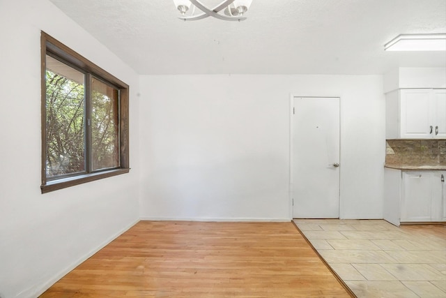 9200 Lagrima De Oro Rd NE, Albuquerque, NM 87111 - unfurnished dining area with light wood-style floors and a chandelier