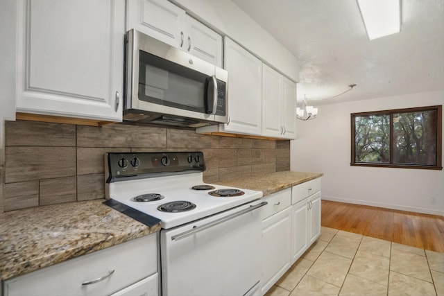 9200 Lagrima De Oro Rd NE, Albuquerque, NM 87111 - kitchen with white range with electric cooktop, stainless steel microwave, white cabinetry, and backsplash