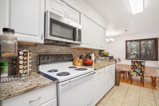 9200 Lagrima De Oro Rd NE, Albuquerque, NM 87111 - kitchen featuring white range with electric stovetop, stainless steel microwave, backsplash, a chandelier, and white cabinets