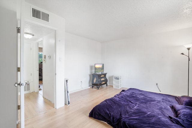 9200 Lagrima De Oro Rd NE, Albuquerque, NM 87111 - bedroom with light wood-type flooring and a textured ceiling