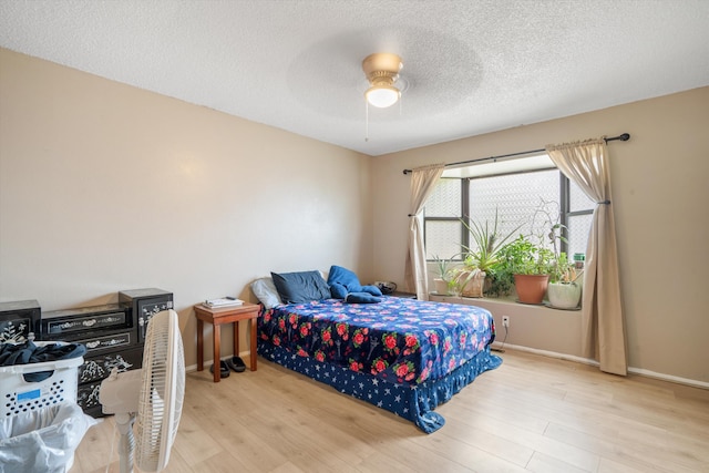 9200 Lagrima De Oro Rd NE, Albuquerque, NM 87111 - bedroom with light wood-style floors, a textured ceiling, and a ceiling fan