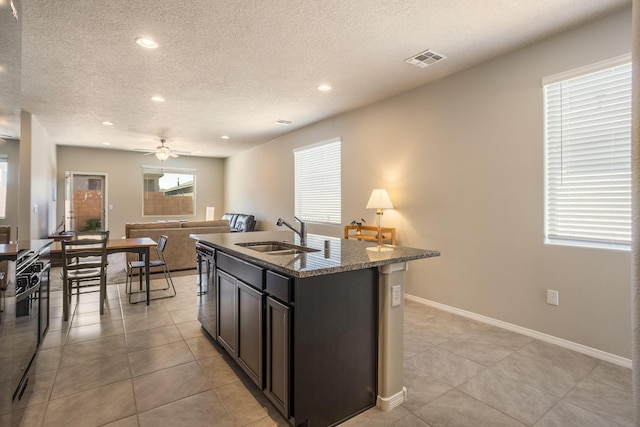 4880 Blackburn Rd, Rio Rancho, NM 87144 - kitchen with a textured ceiling, recessed lighting, a center island with sink, light tile patterned floors, and ceiling fan