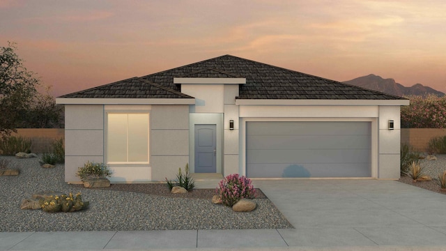 2404 Marble Ave NE, Rio Rancho, NM 87144 - view of front of house with stucco siding, driveway, an attached garage, and a mountain view