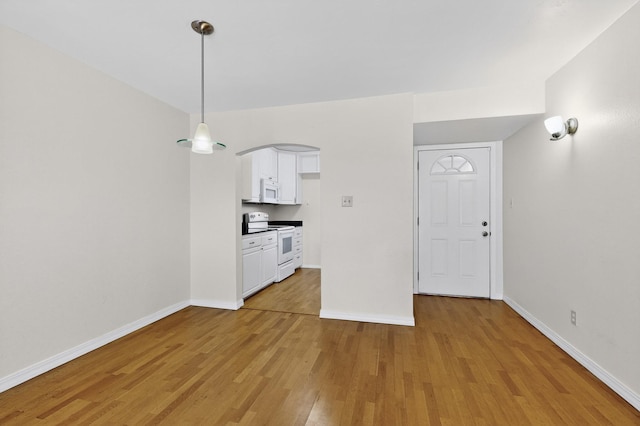 1821 Dartmouth Dr NE Unit 104, Albuquerque, NM 87106 - unfurnished dining area featuring light wood finished floors and arched walkways