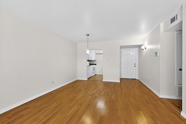 1821 Dartmouth Dr NE Unit 104, Albuquerque, NM 87106 - unfurnished living room featuring light wood finished floors and arched walkways
