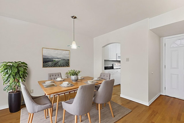 1821 Dartmouth Dr NE Unit 104, Albuquerque, NM 87106 - dining room with arched walkways and light wood-style flooring