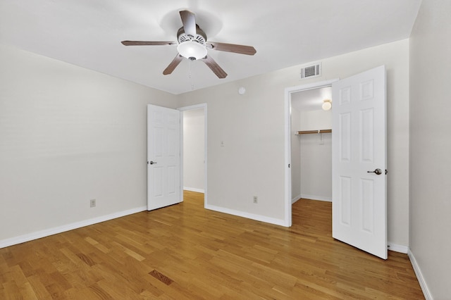 1821 Dartmouth Dr NE Unit 104, Albuquerque, NM 87106 - unfurnished bedroom with light wood-style floors, a walk in closet, and a ceiling fan