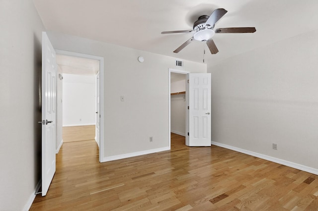 1821 Dartmouth Dr NE Unit 104, Albuquerque, NM 87106 - unfurnished bedroom with light wood-style flooring, a spacious closet, and a ceiling fan