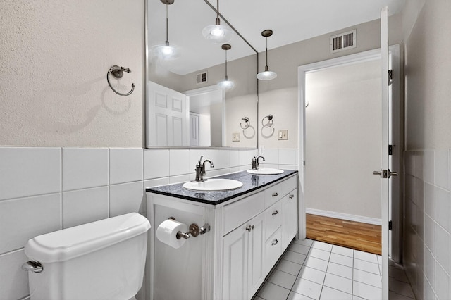 1821 Dartmouth Dr NE Unit 104, Albuquerque, NM 87106 - bathroom featuring tile walls, tile patterned floors, double vanity, and wainscoting