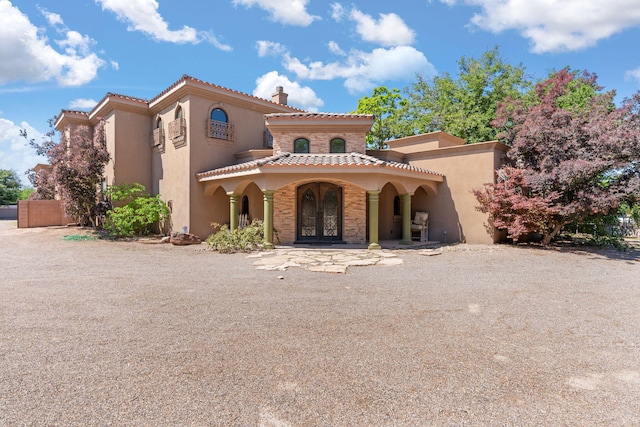 746 Chamisal Rd NW, Los Ranchos, NM 87107 - mediterranean / spanish-style house featuring stucco siding, french doors, a tiled roof, and covered porch