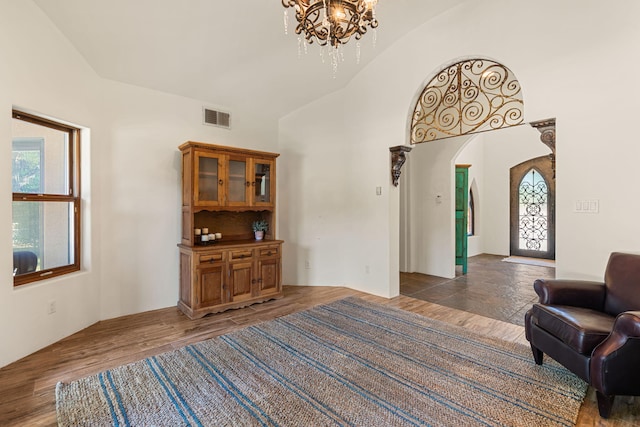 746 Chamisal Rd NW, Los Ranchos, NM 87107 - living room with a chandelier, arched walkways, wood finished floors, and high vaulted ceiling