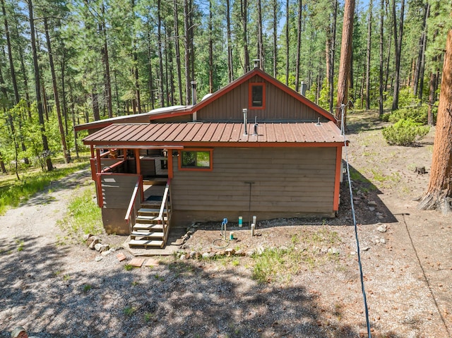 578 Horseshoe Loop, Jemez Springs, NM 87025 - view of property exterior featuring a metal roof, a wooded view, board and batten siding, and stairs