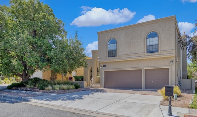 8712 Greenarbor Rd NE, Albuquerque, NM 87122 - mediterranean / spanish-style home featuring a garage, concrete driveway, and stucco siding