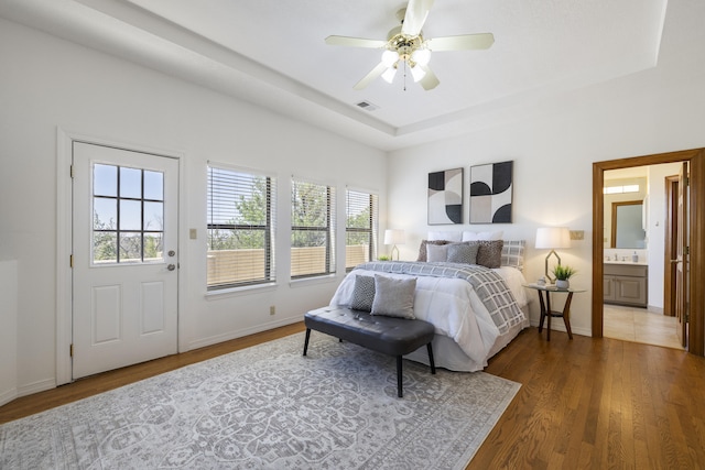 8712 Greenarbor Rd NE, Albuquerque, NM 87122 - bedroom with multiple windows, wood finished floors, and a tray ceiling