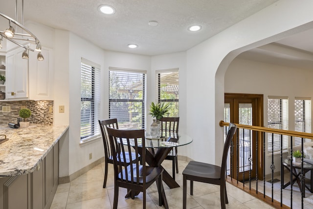 8712 Greenarbor Rd NE, Albuquerque, NM 87122 - dining space with arched walkways, recessed lighting, a textured ceiling, and light tile patterned floors