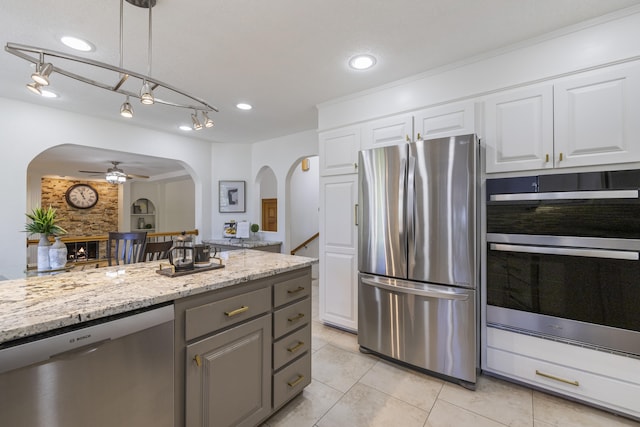 8712 Greenarbor Rd NE, Albuquerque, NM 87122 - kitchen with stainless steel appliances, arched walkways, a ceiling fan, light stone countertops, and recessed lighting