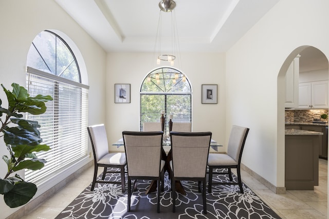 8712 Greenarbor Rd NE, Albuquerque, NM 87122 - dining room featuring plenty of natural light, arched walkways, a tray ceiling, and light tile patterned floors