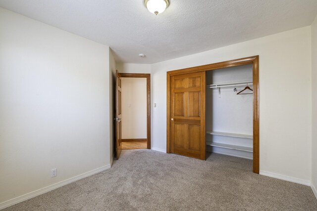 8712 Greenarbor Rd NE, Albuquerque, NM 87122 - unfurnished bedroom featuring carpet, a closet, and a textured ceiling