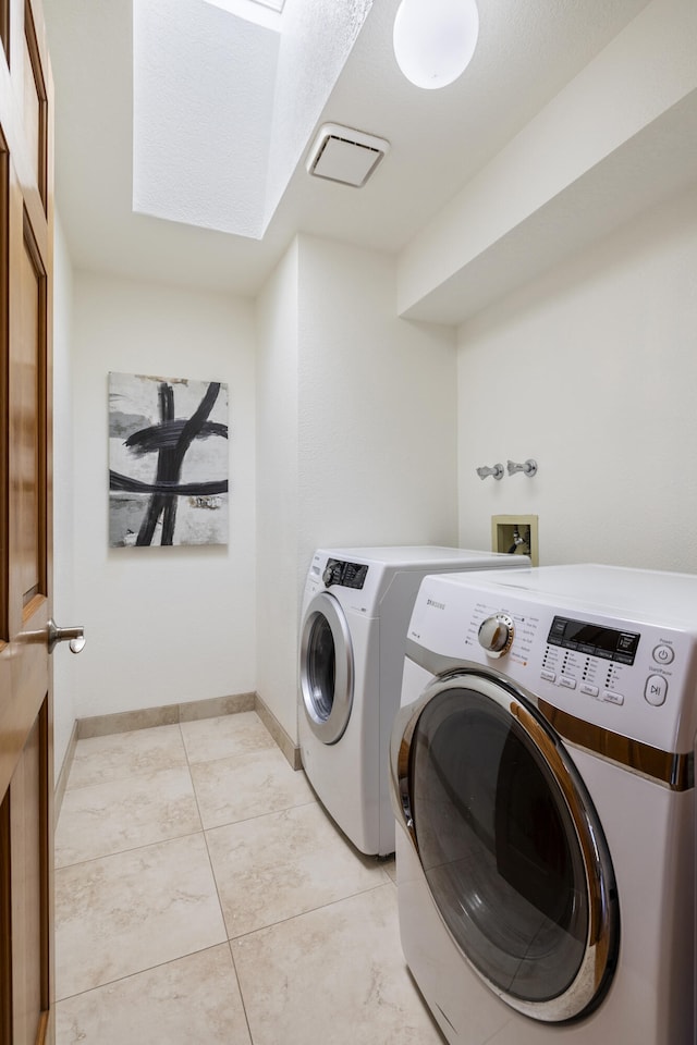 8712 Greenarbor Rd NE, Albuquerque, NM 87122 - washroom featuring washer and dryer, a skylight, and light tile patterned floors