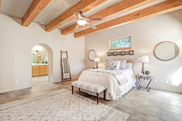 120 Espinosa Rd, Corrales, NM 87048 - bedroom featuring arched walkways, light tile patterned flooring, beamed ceiling, and connected bathroom