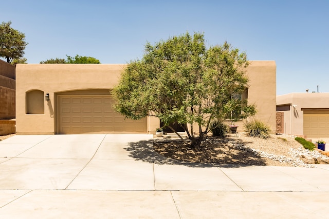 4601 Mi Cordelia Dr NW, Albuquerque, NM 87120 - pueblo-style house with concrete driveway, stucco siding, and an attached garage