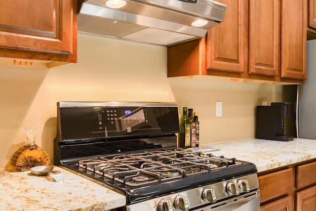 4601 Mi Cordelia Dr NW, Albuquerque, NM 87120 - kitchen with stainless steel gas range, ventilation hood, brown cabinetry, and light stone counters